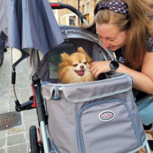 A woman with her dog in a pet stroller